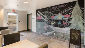 A restaurant with a mural of Columbia Gardens, a sign, and a chalkboard menu. - Red Lion Inn & Suites Butte (Butte)