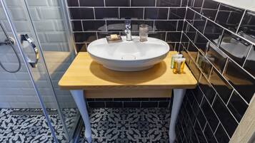 Une salle de bain avec un lavabo blanc, un carrelage noir et blanc au sol et des carreaux noirs sur les murs.
