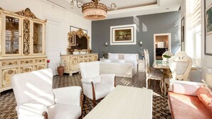A room with a large ornate cabinet, a bed with white linens, a chandelier, and a painting on the wall. - Cezayir Rooms (Istanbul)