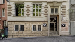 A multi-story building with a classical architectural style, featuring a symmetrical facade with evenly spaced windows and decorative moldings. - Cezayir Rooms (Istanbul)