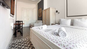 A hotel room with a bed, a chair, a wardrobe, and a desk. - Cezayir Rooms (Istanbul)
