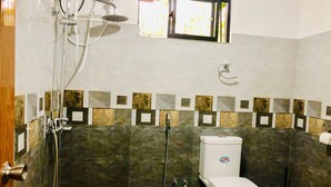 A bathroom with a toilet, shower, and a window. - Family Ties GUEST INN (Bandarawela)