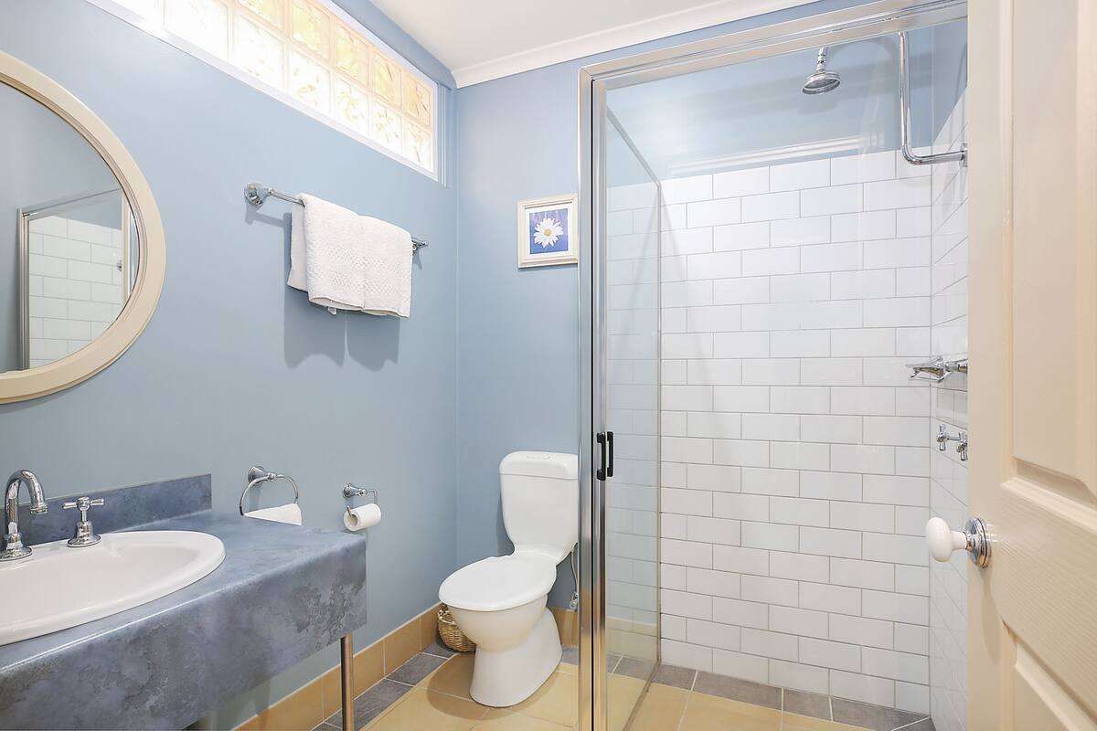 A bathroom with a sink, toilet, and glass-enclosed shower.