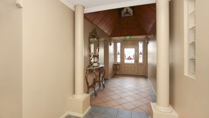A hallway with columns, a tiled floor, and an exit sign. - Grand Central Accommodation B&B Cobden (Cobden)