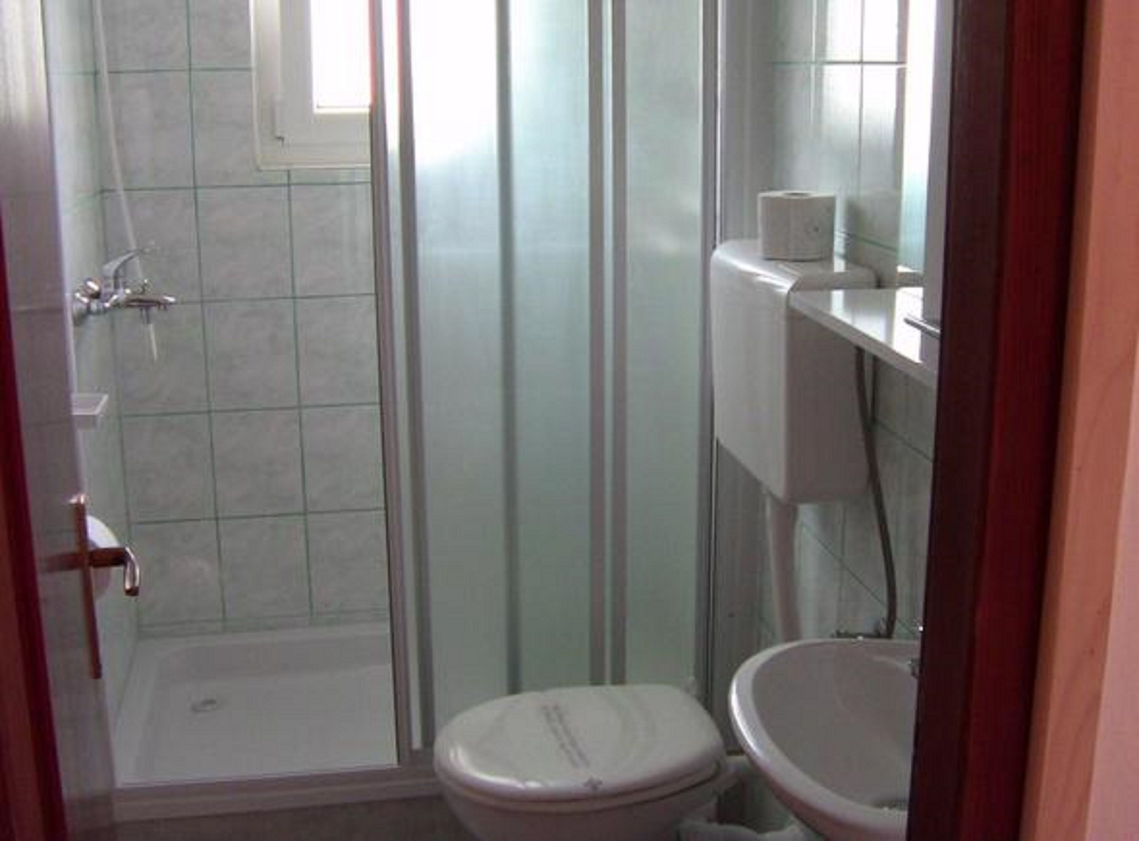 Une petite salle de bain avec une douche, des toilettes et un lavabo.