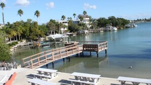 A marina with docked boats, a wooden pier, and picnic tables.