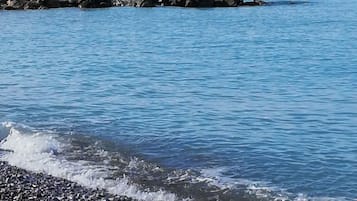 On the beach, black sand, beach umbrellas, beach bar