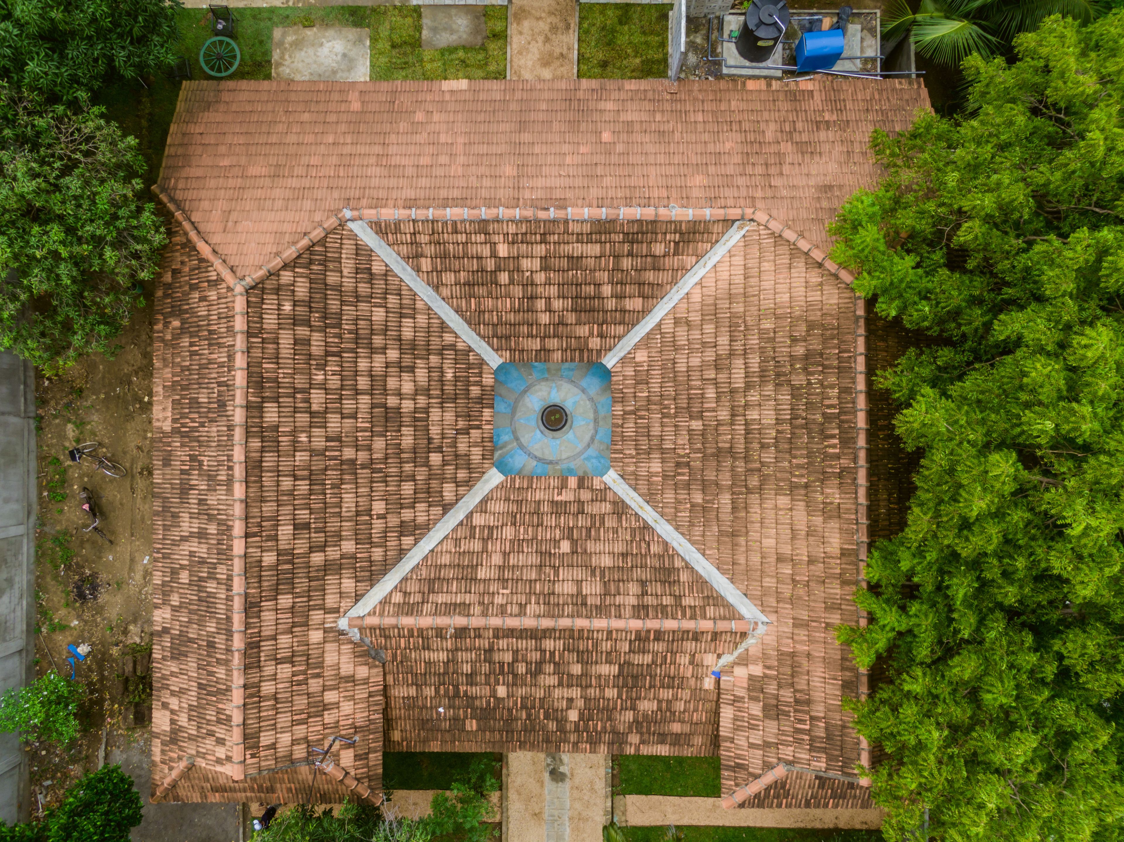 An aerial view of a building with a central courtyard, surrounded by greenery.