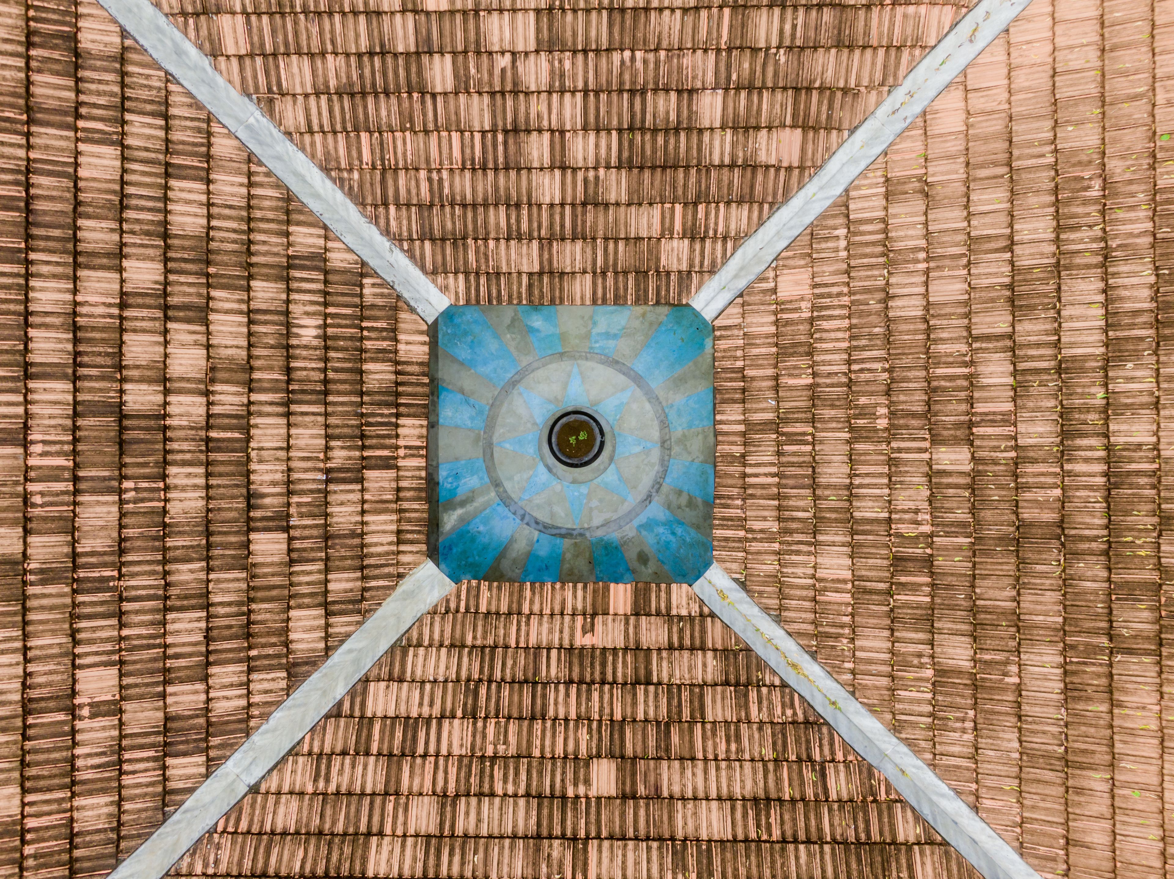 A square tile with a blue and gray pattern, surrounded by a bamboo-like textured floor.