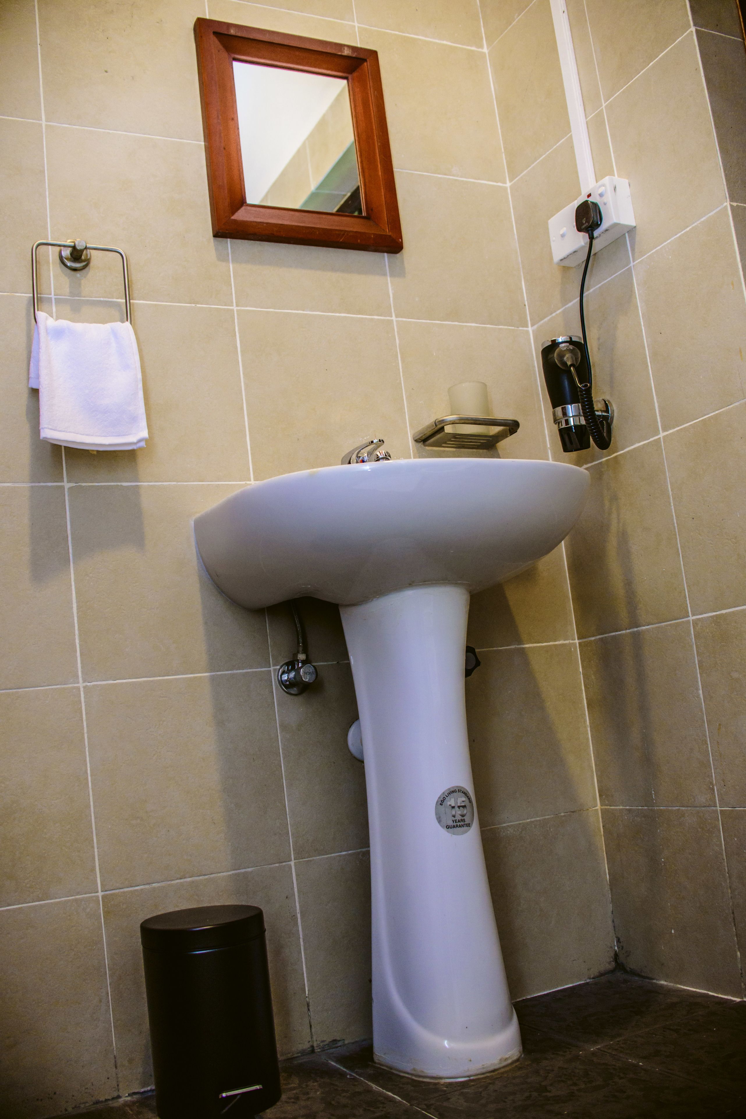 A bathroom with a white sink, a mirror, and a towel rack.