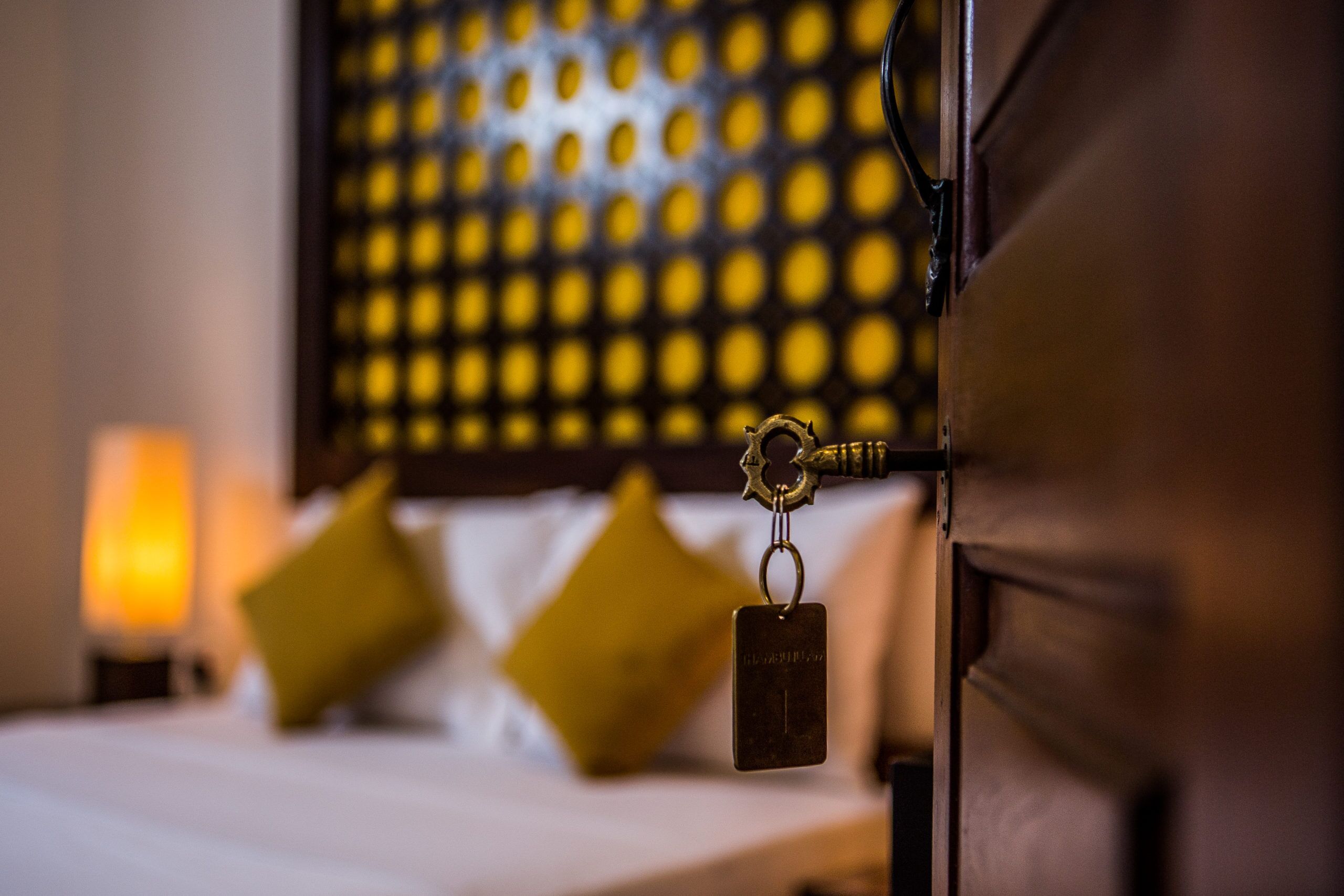 A bed with a headboard, a keychain, and a pillow.
