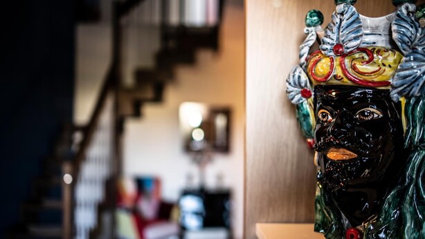 A ceramic sculpture with a face, placed on a shelf. - B&B Caravello (Milazzo)