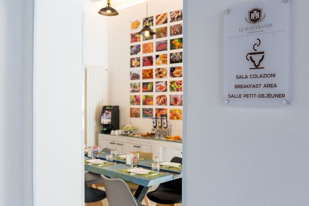 Ein Frühstücksbereich mit einer Wand voller Essensfotos, einem Schild mit einer Kaffeetasse und einem Hinweis, dass es sich um ein Luxuszimmer handelt.