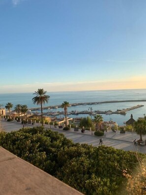 A coastal view with a marina, palm trees, and a clear sky. - Le Maestranze Deluxe Rooms (Sciacca)