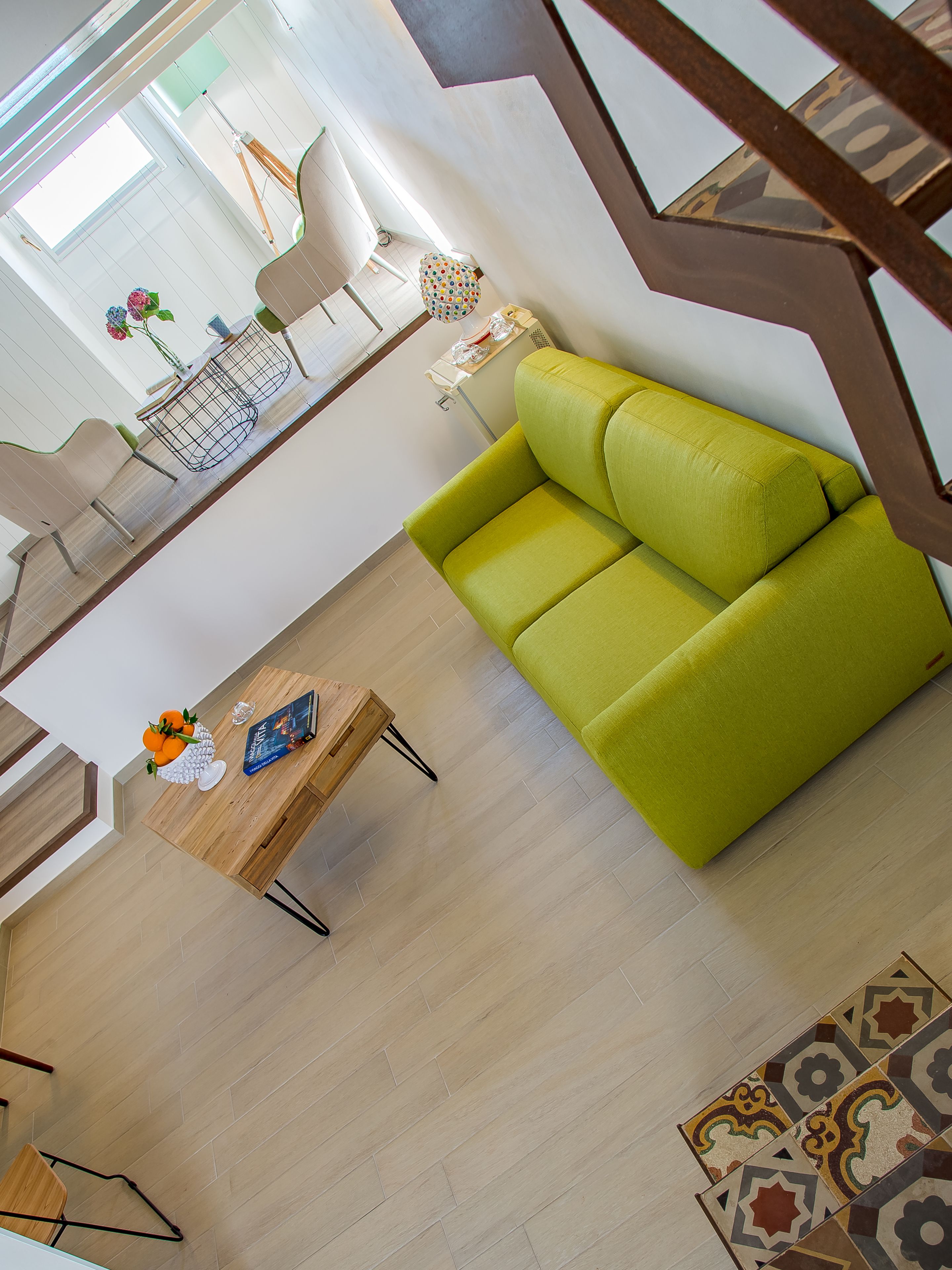 Un salon moderne avec un canapé vert, une table basse en bois et un coin repas comprenant des chaises et une table.