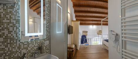 Un baño moderno con un lavamanos grande, un espejo y una zona de ducha.