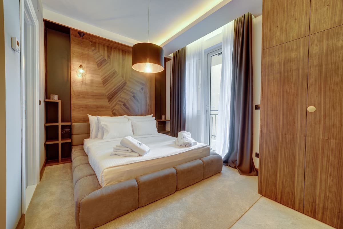 Ein modernes Schlafzimmer mit einem großen Bett, einem Holzschrank und einer eingebauten Regaleinheit.