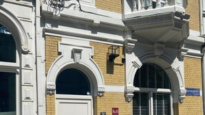A building with a white door, a small window with shutters, and a sign reading "B&B".