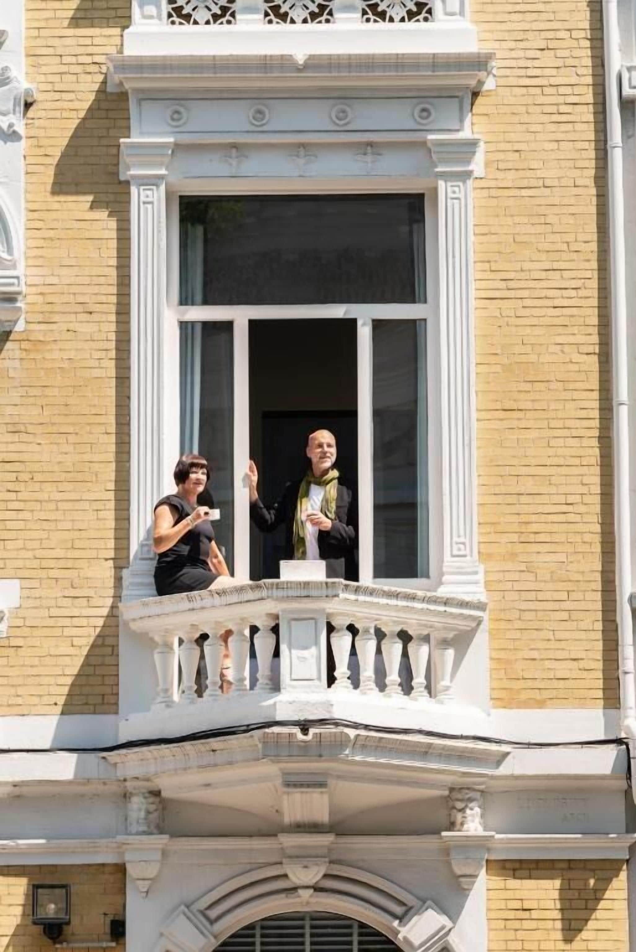 Een gebouw met een balkon, een raam en een bakstenen muur.