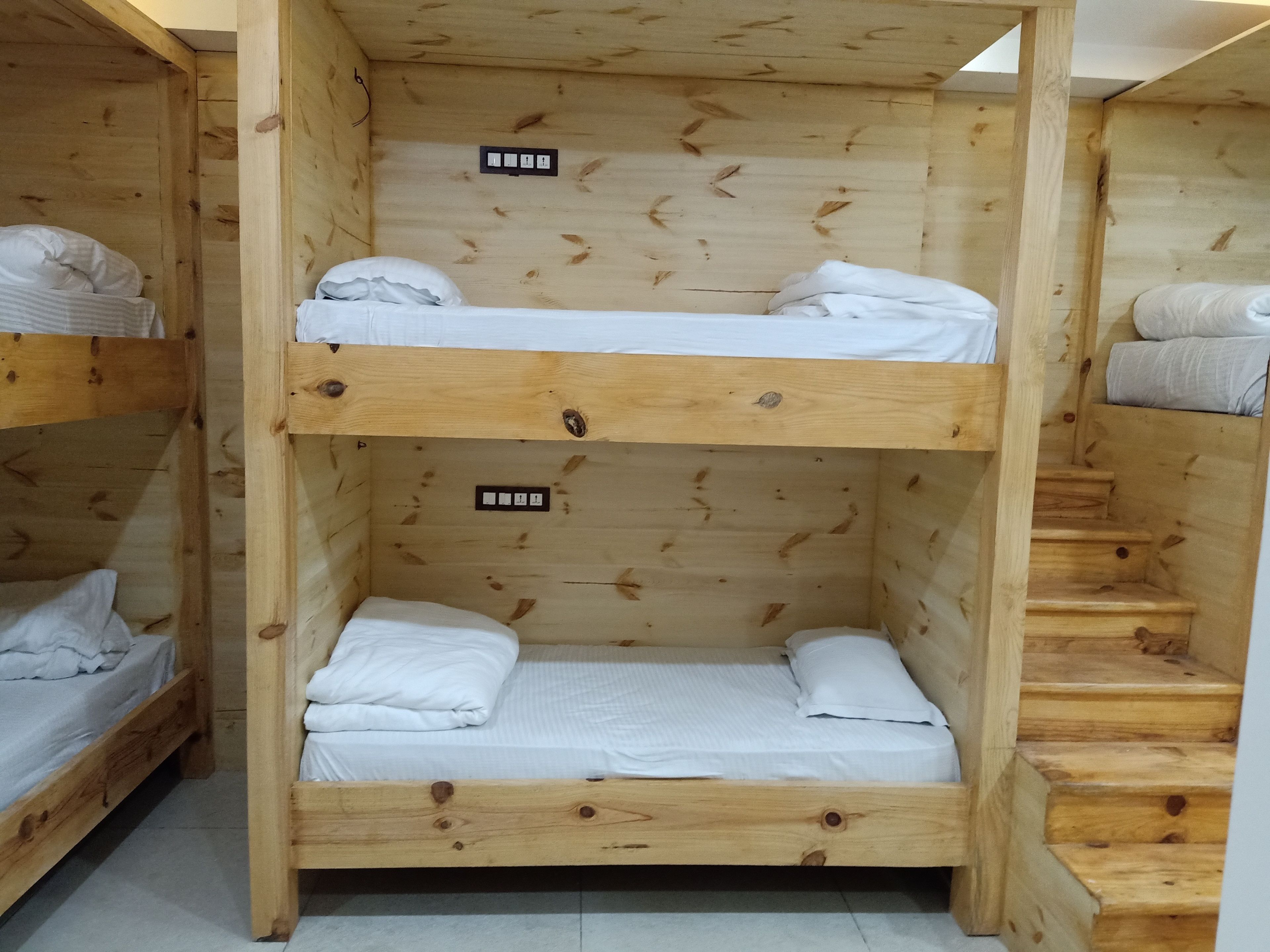 A wooden bunk bed room with a staircase.