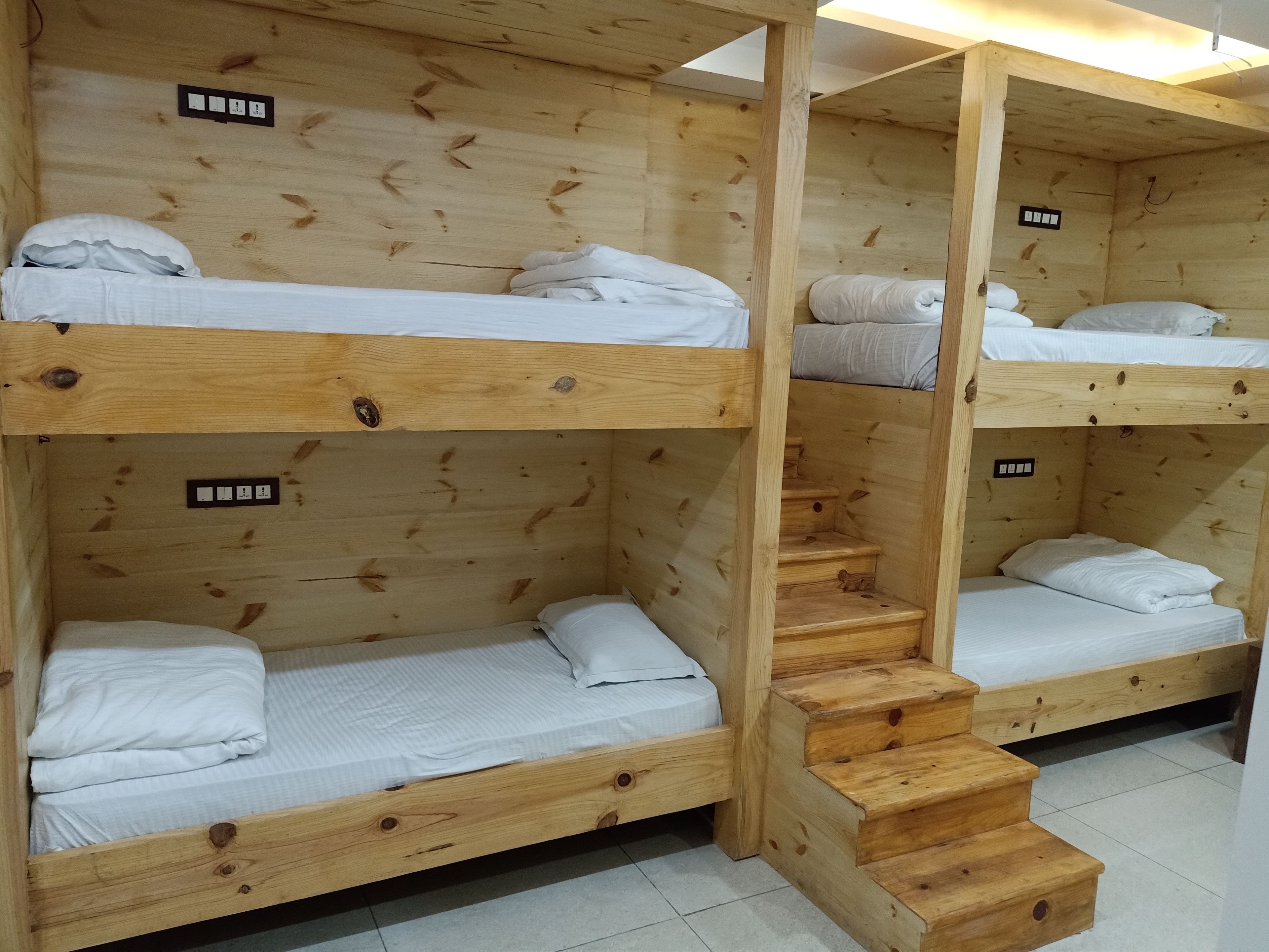 A bunk bed room with wooden walls and a staircase.
