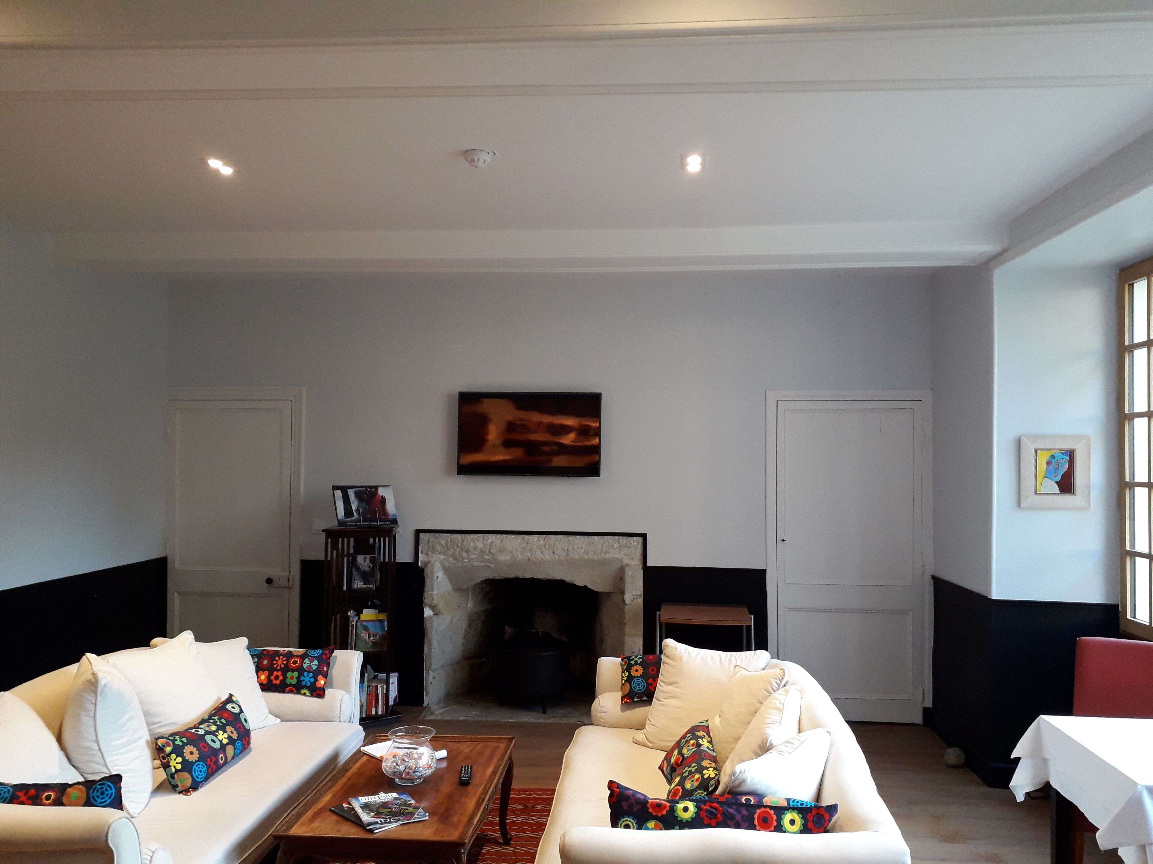 A living room with a fireplace, sofas, a coffee table, and a television.