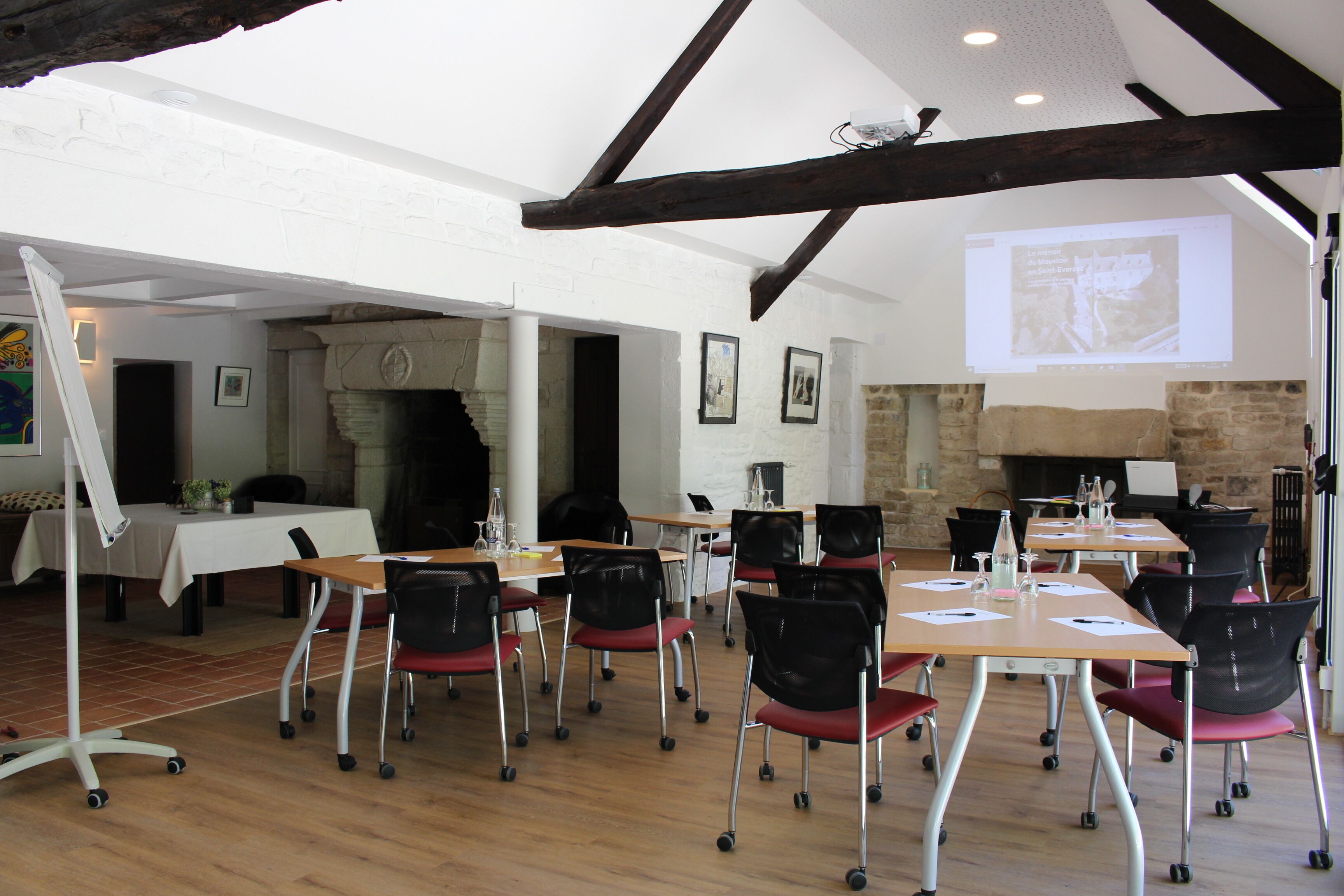 Une salle de conférence équipée de tables, de chaises et d’une cheminée.