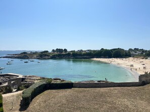 A coastal beach with clear waters, boats, and a sandy shore. - Ploemeur Lomener 2-Room Apt Balcony (Ploemeur)