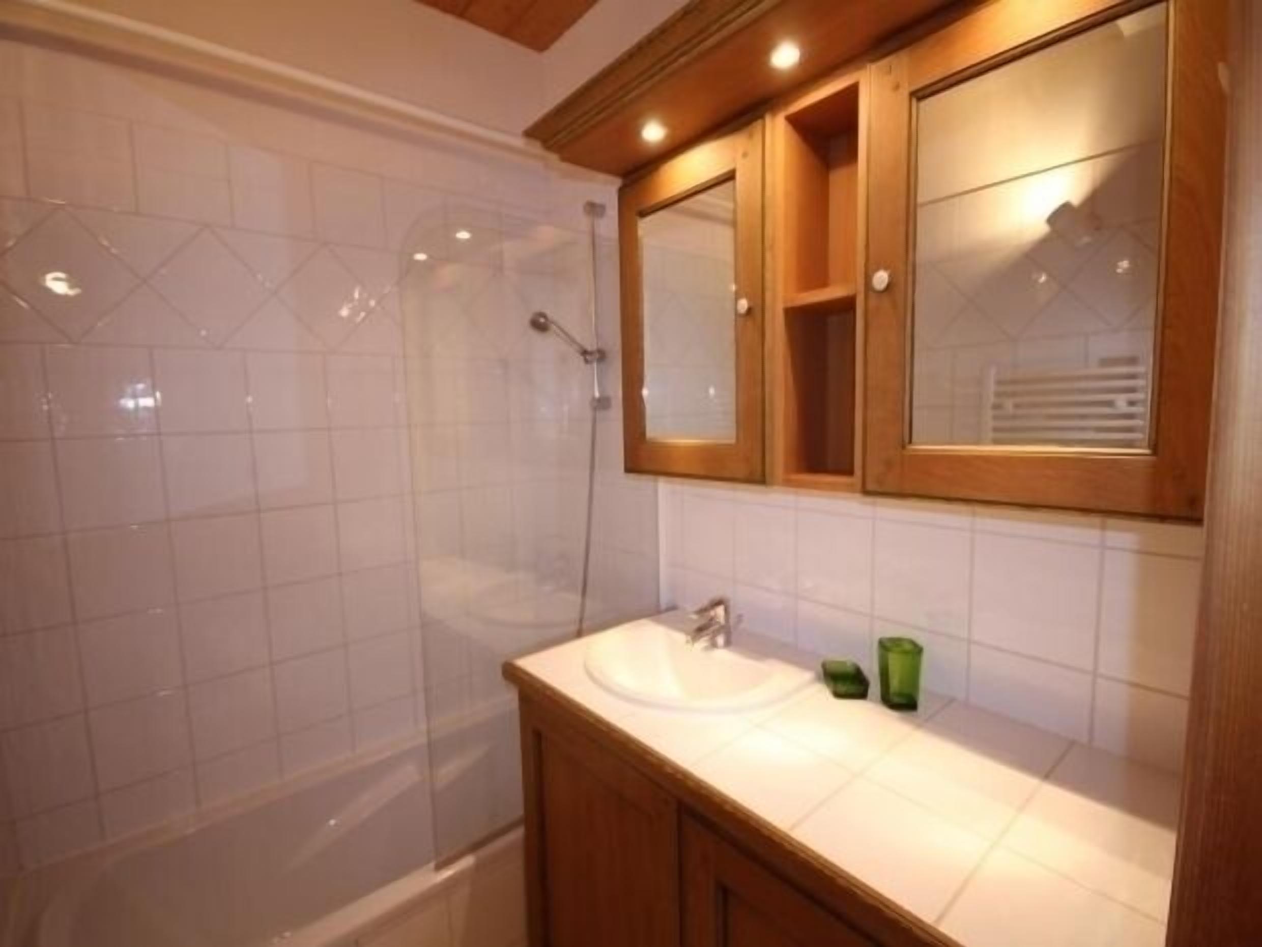A bathroom with a shower, a sink, and a mirror.