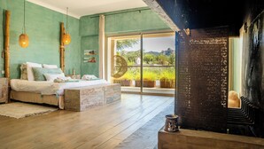 Une chambre à coucher avec un lit, un plancher en bois, une grande fenêtre et un mur noir sur lequel on a écrit.