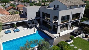 Un bâtiment moderne à deux étages doté d’une piscine, d’un espace extérieur aménagé et d’une pelouse bien entretenue.