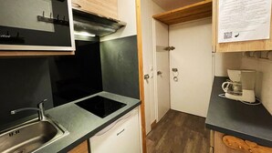 A compact kitchen with a sink, stove, and a coffee maker. - Renovated ski-in studio, 4 people, Les Menuires (Les Menuires)