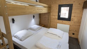 A bunk bed room with wooden walls and a window. - Renovated 2-room with parking and wifi, pets allowed - Les Saisies (Les Saisies)
