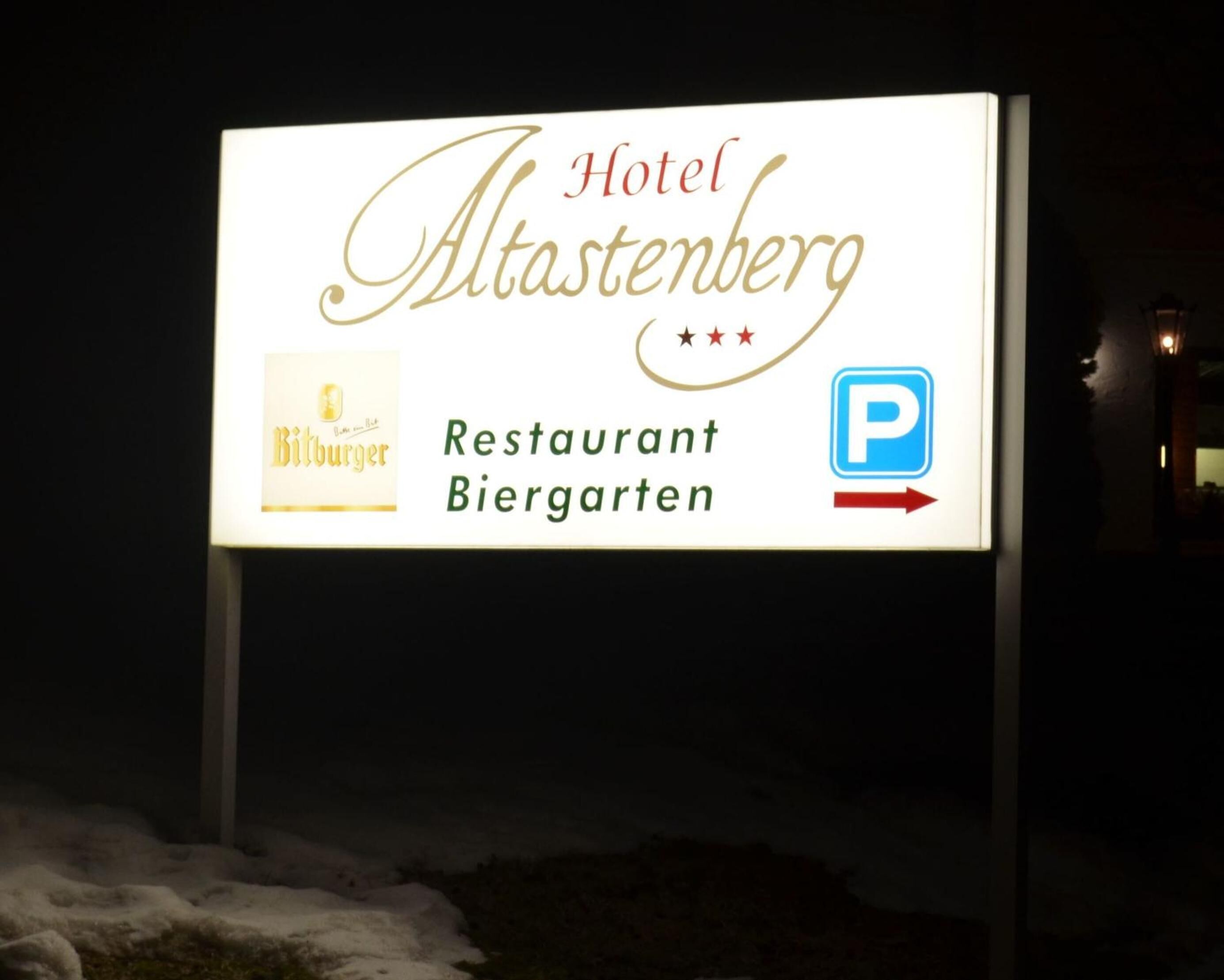 A sign for Hotel Altastenberg, Restaurant Biergarten, with a parking symbol and a burger logo.
