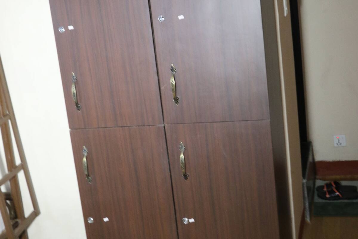 A large wooden wardrobe with multiple compartments and handles.