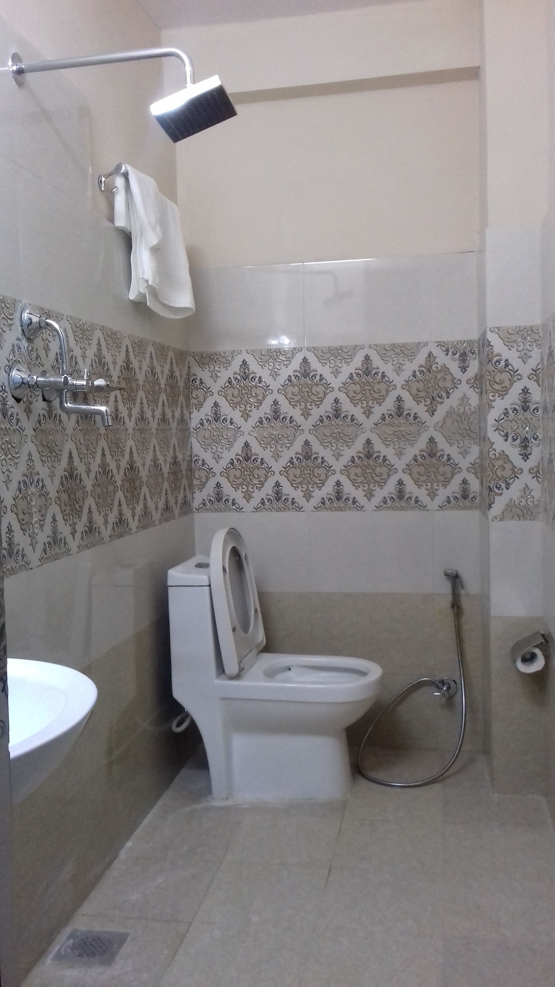 A bathroom with a toilet, a shower, and a sink.