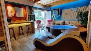 A modern interior with a bar area, a massage chair, and a large window offering a view of the outdoors.