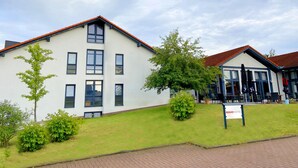 A modern hotel with a flat roof, multiple windows, and a sign indicating it is a hotel. - Regiohotel Wittekind Burg (Burg)