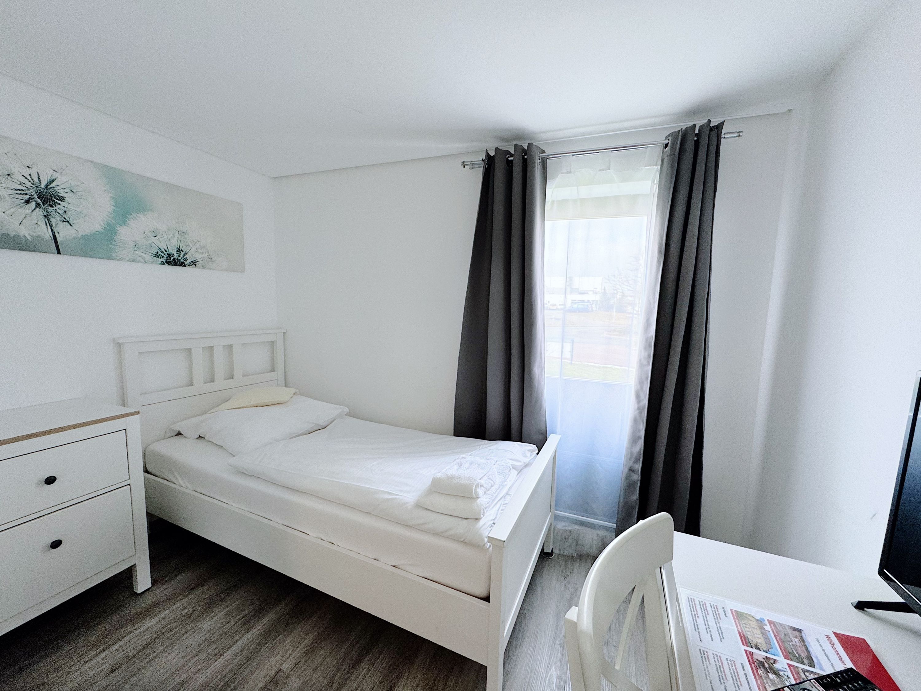 Une pièce comprenant un lit, un bureau et une chaise.