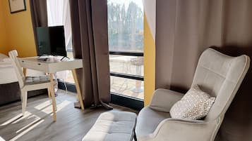 Ein modernes Hotelzimmer mit Schreibtisch, Stuhl und Hocker.
