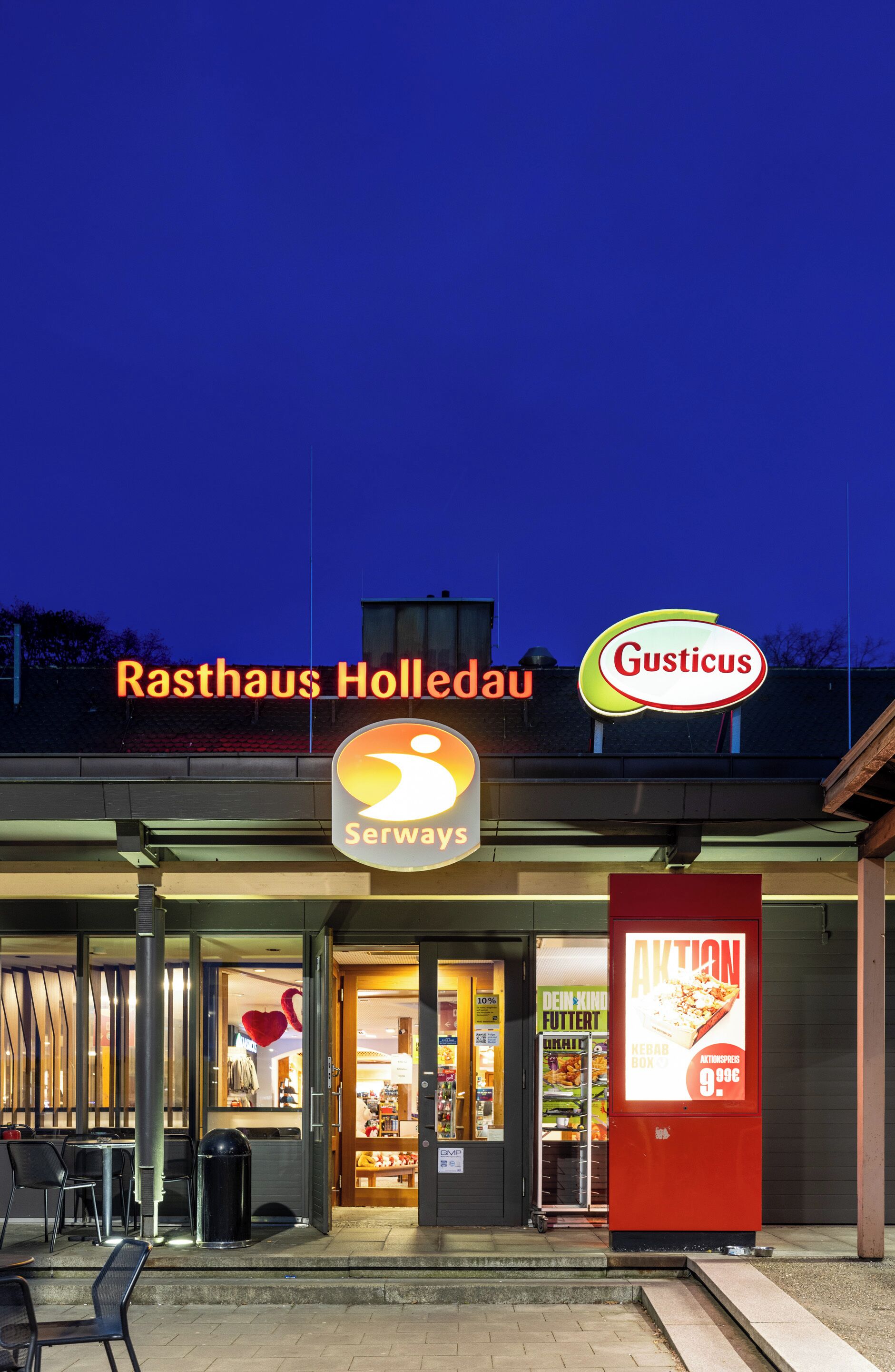 Ein Restaurant namens 'Rasthaus Holledau' mit Schildern für 'Gusticus' und 'Serways'.