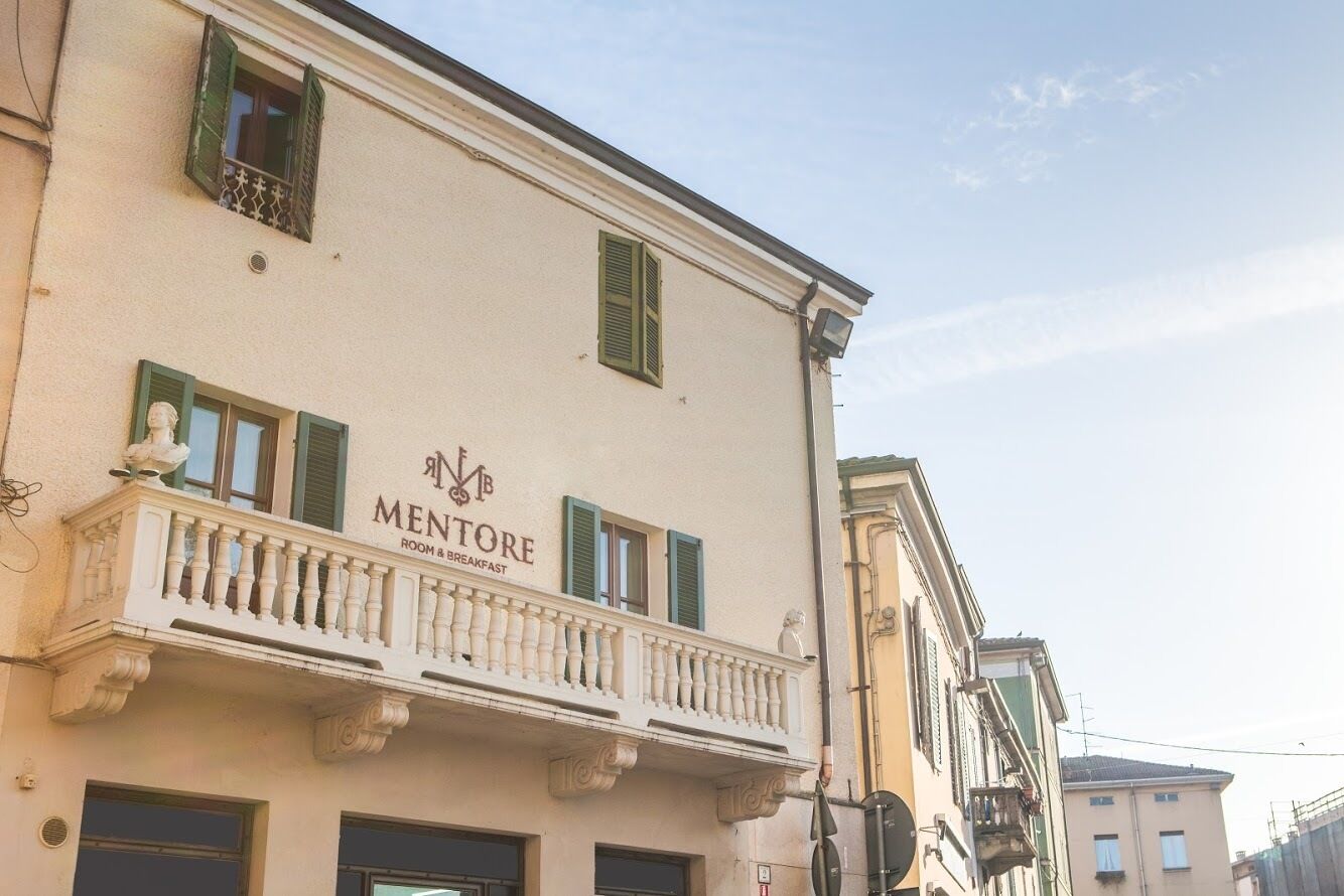 Un bâtiment sur lequel on peut lire l’inscription suivante : « MENTORE ROOM & BREAKFAST ».