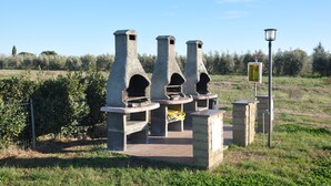 A stone structure with multiple chimneys, a paved area, and a lamp post. - Large four-room apartment with swimming pool near the sea (Vada)