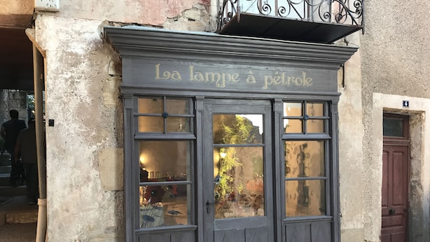 Fachada de un edificio con un letrero que dice "La lampe à pétrole".