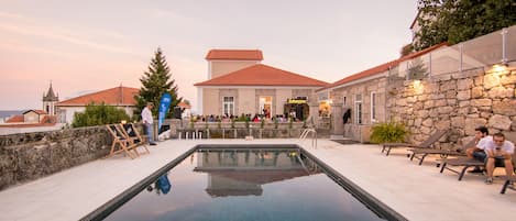 Una piscina al aire libre de temporada, sillones reclinables de piscina