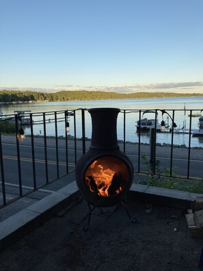 Un poêle à bois offrant une vue sur un lac et des bateaux au loin.