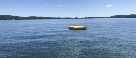 A clear view of a lake with a yellow dock extending into the water.