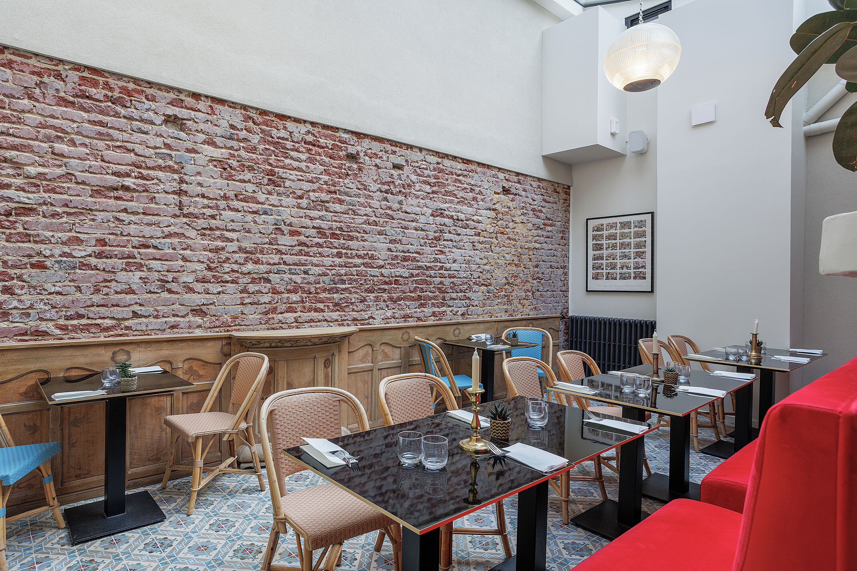 Een restaurant met bakstenen muren, houten meubels en een betegelde vloer.