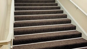A carpeted staircase with a handrail and a light-colored wall. - London Residency Inn (London)
