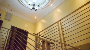 A staircase with a metal railing and a chandelier. - House X (Abuja)